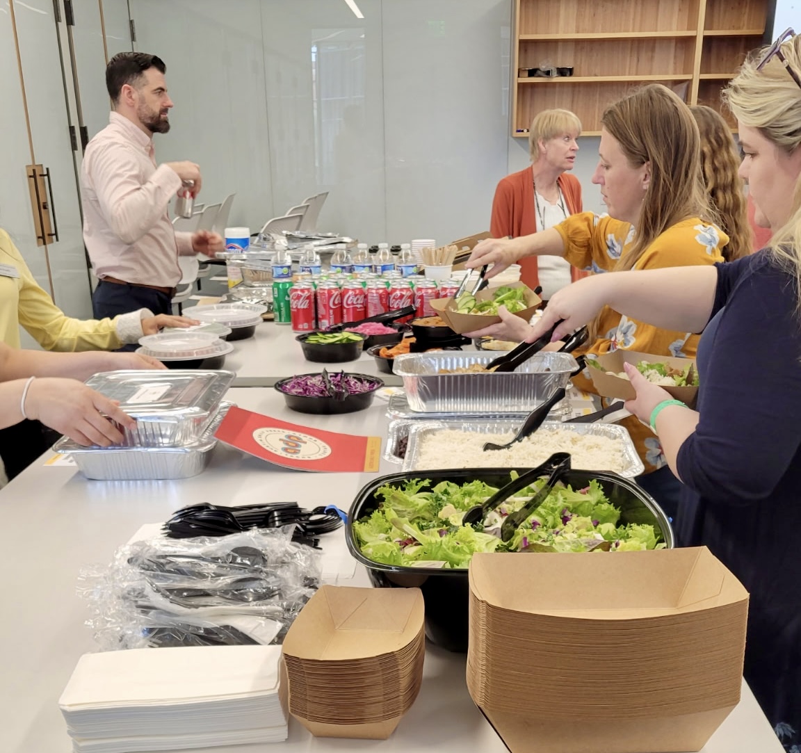 ADP office catering buffet setup in Austin, TX — team serving themselves from a full spread